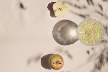 Summer still life composition made of apples and glass on pastel background white cloth. Creative layout. Freshness concept. Top view. Flat lay. Copy space