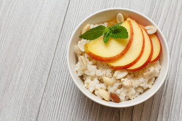Sorghum salad with nuts and fresh peach on wooden background.
