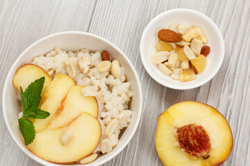Sorghum salad with nuts and fresh peach on gray boards.