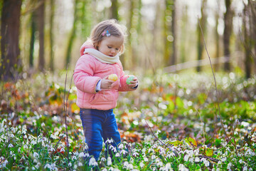 Cute little girl playing egg hunt on Easter