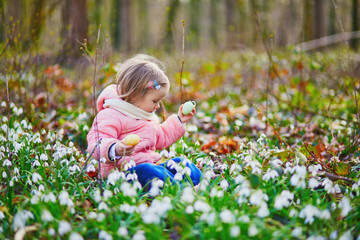 Cute little girl playing egg hunt on Easter