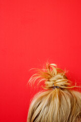 Naklejka premium Blonde hair bun on the red background