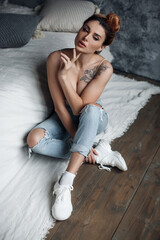 pretty woman near bed indoors in interior. serious model posing