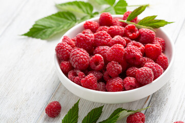 White bowl full of raspberries