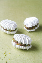 French Vanilla Meringue Sandwich Cookies with Chocolate Ganache filling and Pistachios.