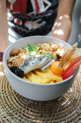 Healthy pineapple, mango and strawberry smoothie bowl with granola, seeds , almond fresh strawberries and fresh apple in White ceramic bowl.detox,