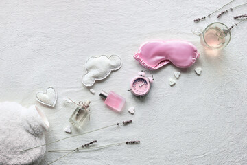 Healthy night sleep concept. Off white, ivory textile flat lay. Pink hyacinth flower.Sleep mask, tea, glass,. Soft toys, clouds and heart. fluffy white fake fur bottle warmer.
