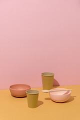 Abstract composition with recycle dishes on yellow and pink background. Conceptual minimalist art, still life, copy space