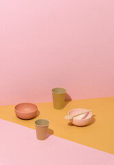 Abstract composition with recycle dishes on yellow and pink background. Conceptual minimalist art, still life, copy space
