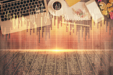 Financial market graph and top view computer on the desktop background. Double exposure. Investment...