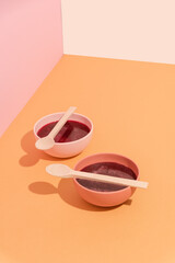 Plates with beetroot soup, borscht on yellow table, abstract composition. Conceptual art, healthy still life, copy space