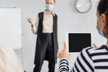 African american woman holding digital tablet with blank screen near speaker