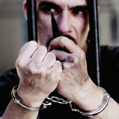 Upset handcuffed man smoking with a knife imprisoned for crime, punished for serious villainy.