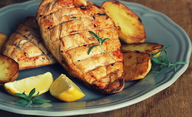 Grilled chicken breast with potatoes . Home made food. Concept for a tasty and healthy meal. Wooden background
