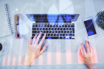 Double exposure of woman hands working on computer and forex chart hologram drawing. Top View. Financial analysis concept.