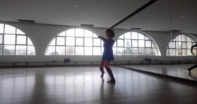 African-american woman dancing contemporary modern routine in dance studio