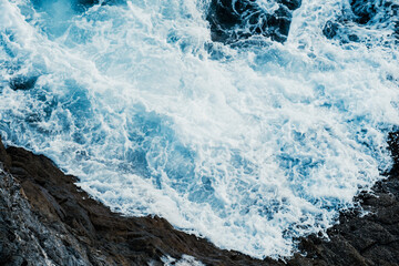 Natural texture of rough sea surface breaking against rocks