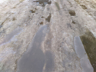 melted snow on a broken and destroyed road