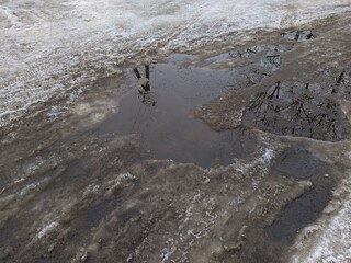 melted snow on a broken and destroyed road