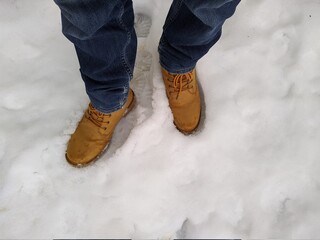 first person view man bend down the head looking for his boots standing on snow