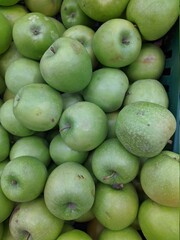 Fototapeta na wymiar lot of green apples in the market closeup photo