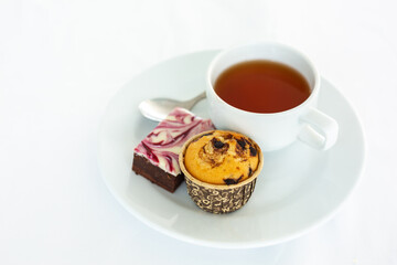  cup of tea with cake on white tablecloth