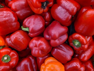 lot of red bell pepper in the market closeup photo