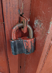 old and large padlock covering a wooden door