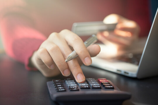 Young woman using calculator with credit card for shopping internet online shopping ,selective focus.