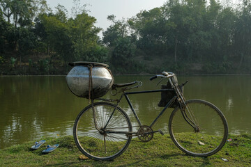 A bicycle in front of a lake in Malda, West Bengal, India.