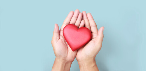 Hands holding  red heart. heart health donation concepts