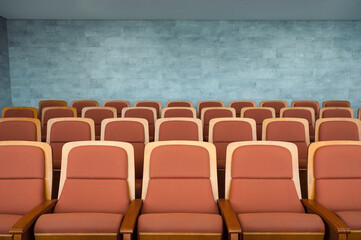 Fototapeta premium Row of brown theatre seats and marble wall in auditorium