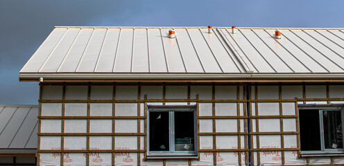 Vendée, France; January 24, 2021: white zinc roof, Tyvek Dupond de Nemour rain screen, construction site for the future Saint Gilles Croix de Vie high school.

