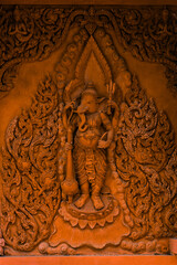 Fototapeta na wymiar Ganesha on the walls of a Buddhist temple on Koh Samui. Wat Ratchathammaram, one of the iconic temples of Koh Samui. Red temple