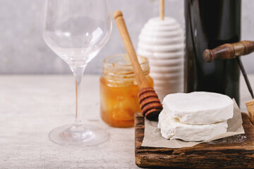 Goat cheese served with honey and bottle of red wine