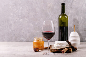 Goat cheese served with honey and bottle of red wine
