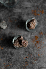
Homemade chocolates with coconut flakes and cocoa powder on a gray concrete table. Sweets background. view from above.