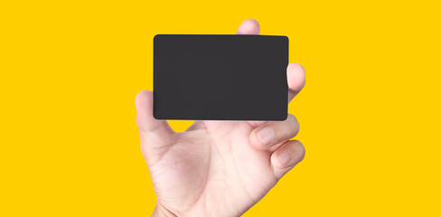 Close up of hand holding blank black card. Credit card in hand
