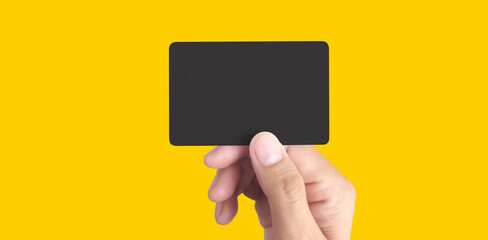 Close up of hand holding blank black card. Credit card in hand