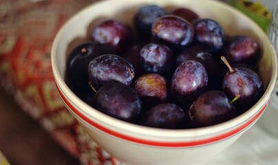 plums in a bowl on the table. organic tasty fruits from the orchard