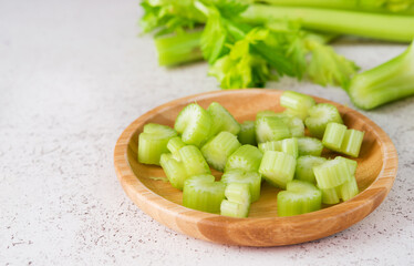 Fresh celery stalks cut into pieces for cooking, selective focus