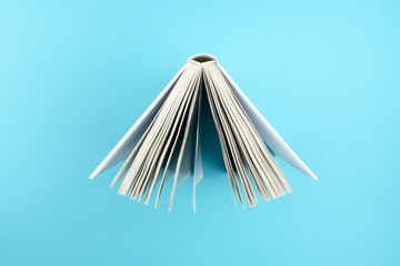 directly above view of top of open hardcover book on blue background