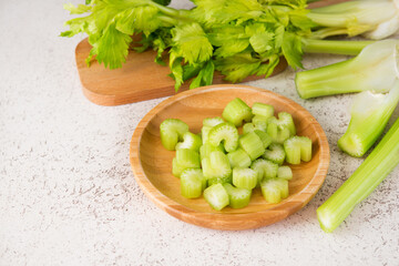 Fresh celery stalks cut into pieces for cooking, selective focus