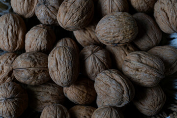 walnuts scattered and heaped on a leather-like surface