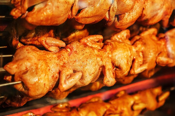 Fried chicken on a spit in an electric grill oven.