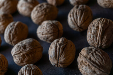 walnuts scattered and heaped on a leather-like surface