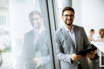 Young modern businessman using digital tablet in the office