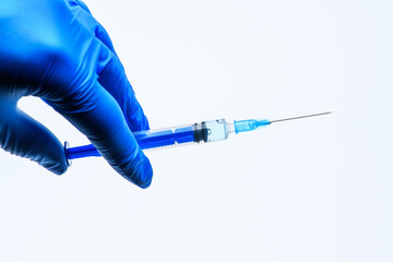 The Coronavirus Vaccine and Syringe injection in the hand in a medical glove on a white background. The concept of protection against Coronavirus infection, COVID-19. Healthcare and medical concept.
