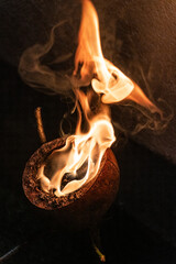 Zbliżenie na ogień na ciemnym tle, naturalna azjatycka pochodnia z kokosa. © insomniafoto