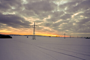 Strommast auf einem Feld - Energietransport über Land - Regenerative Energie